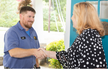  Love Plumbing Air & Electrical technician shaking homeowners hand in doorway